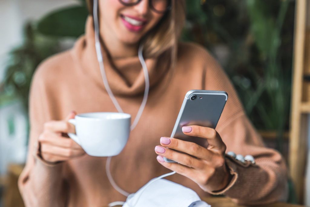woman with coffee mug and cell phone
